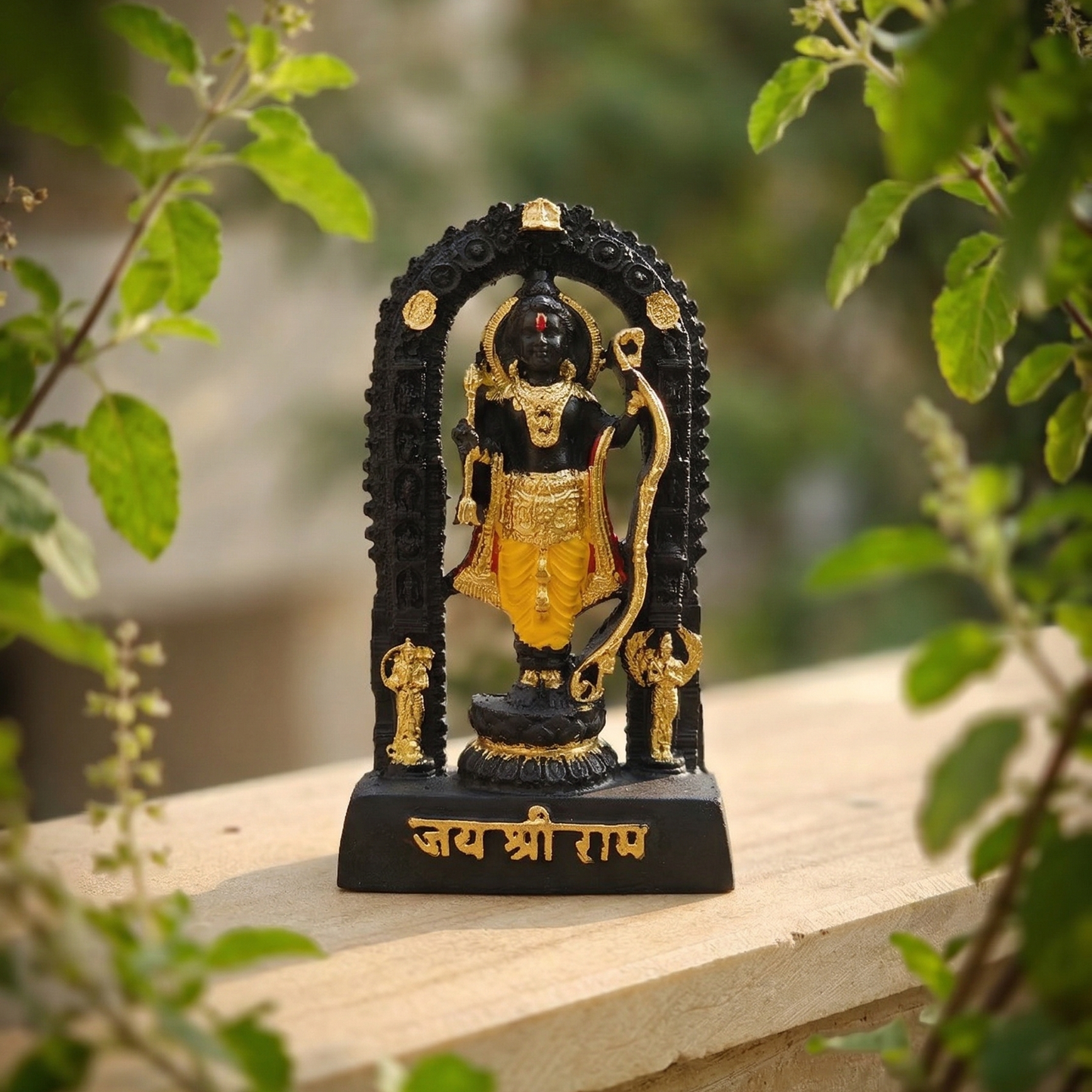 Sacred black Shri Ram Lalla murti standing inside an archway, richly adorned with golden jewelry and garments, with Jai Shri Ram inscribed on the base surrounded by tulsi tree