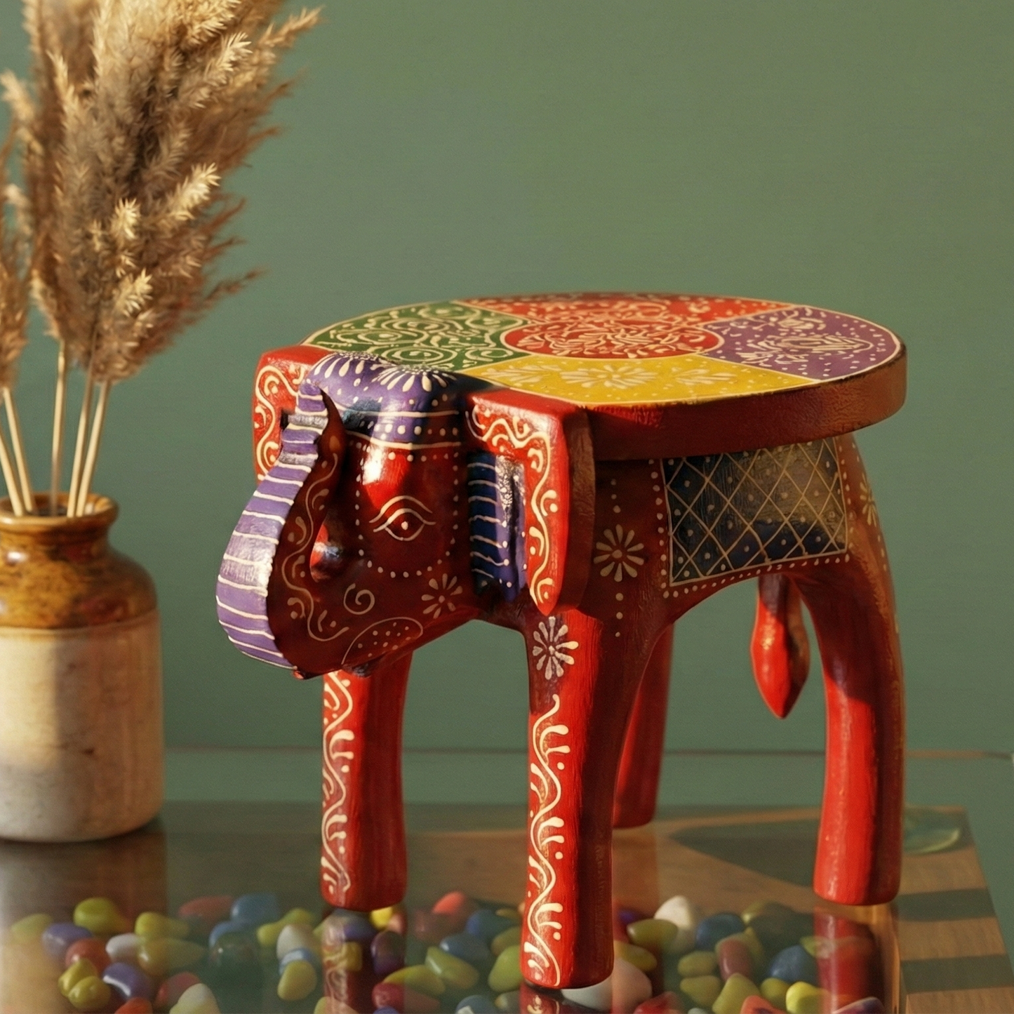 Colorful wooden elephant stool used as side table in Indian living room 