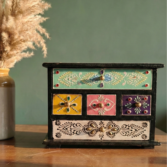 Hand-painted wooden mini chest with 5 colorful drawers (green, pink, yellow) placed on a table for home decor and jewelry storage.