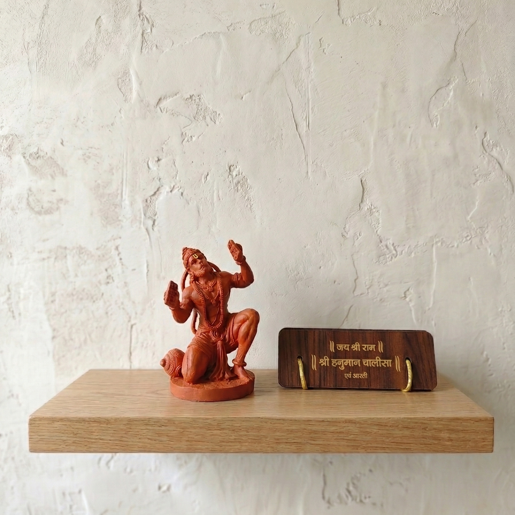 Hanumanji Sinduri with Hanuman Chalisa placed on a shelf on white wall background
