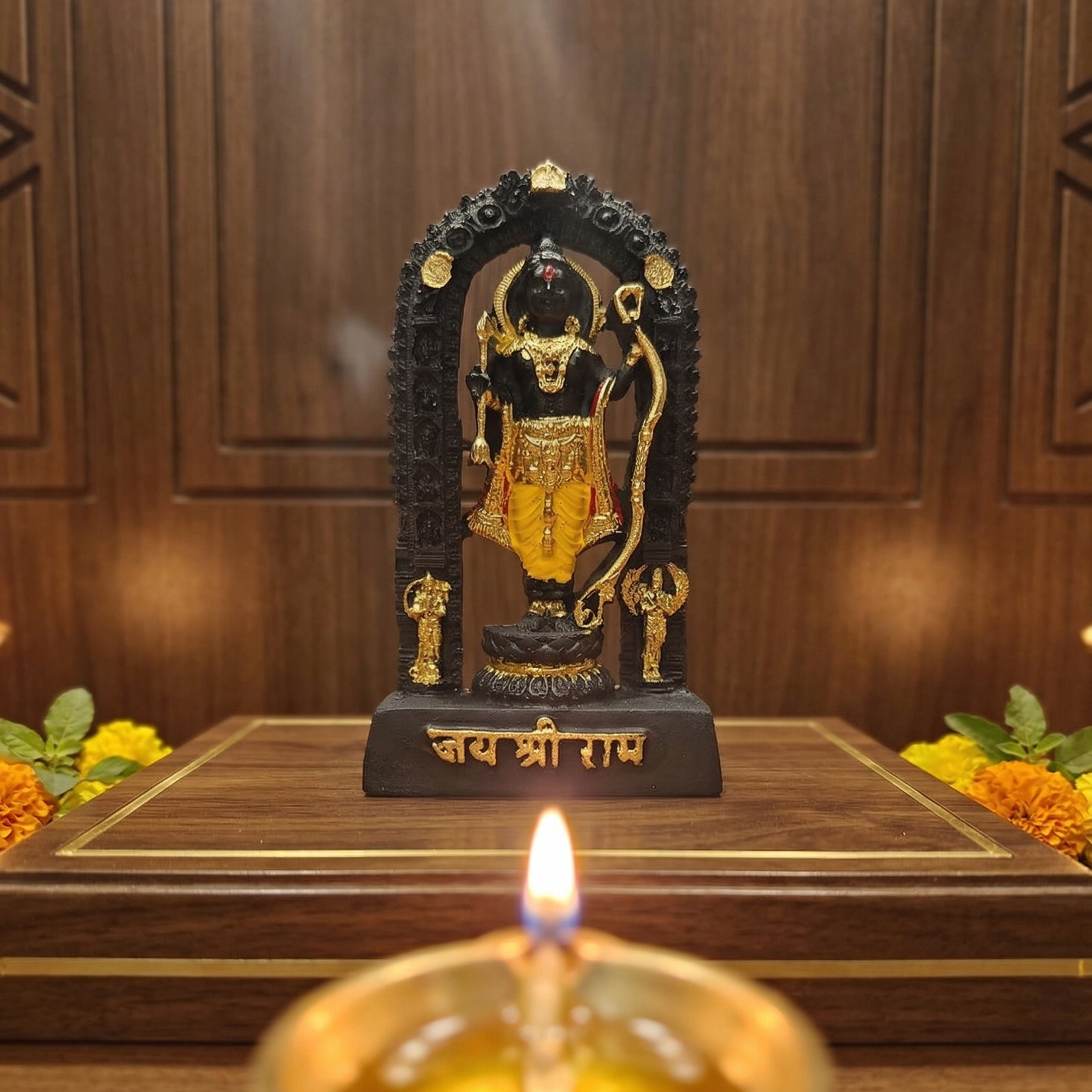Sacred black Shri Ram Lalla murti standing inside an archway, richly adorned with golden jewelry and garments, with Jai Shri Ram inscribed on the base with diya lit infront of the idol and flowers on either side