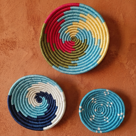 Set of assorted colorful Sabai grass handwoven baskets featuring vibrant geometric and spiral patterns.