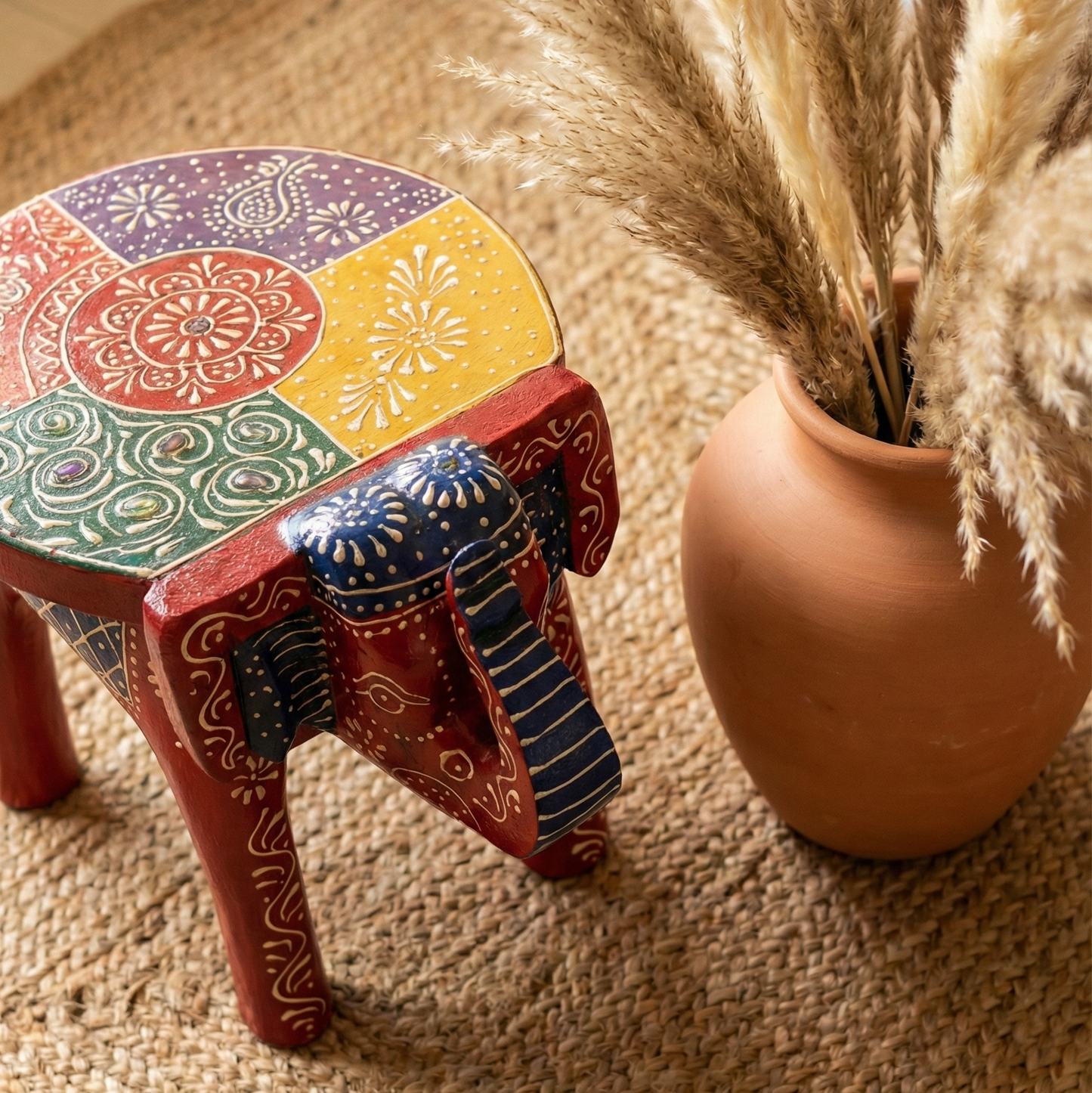 Hand-painted wooden elephant stool featuring colorful mandala art on the seat. Red and multicolor Rajasthani low stool perfect for pooja room or living room decor.