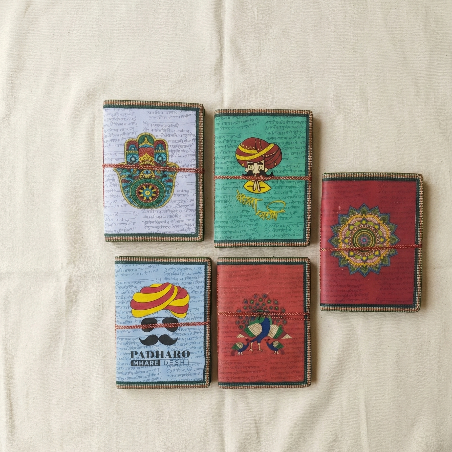 Assorted handmade cotton paper notebooks with Indian art designs like mandala and peacock - Customer receives one random design.