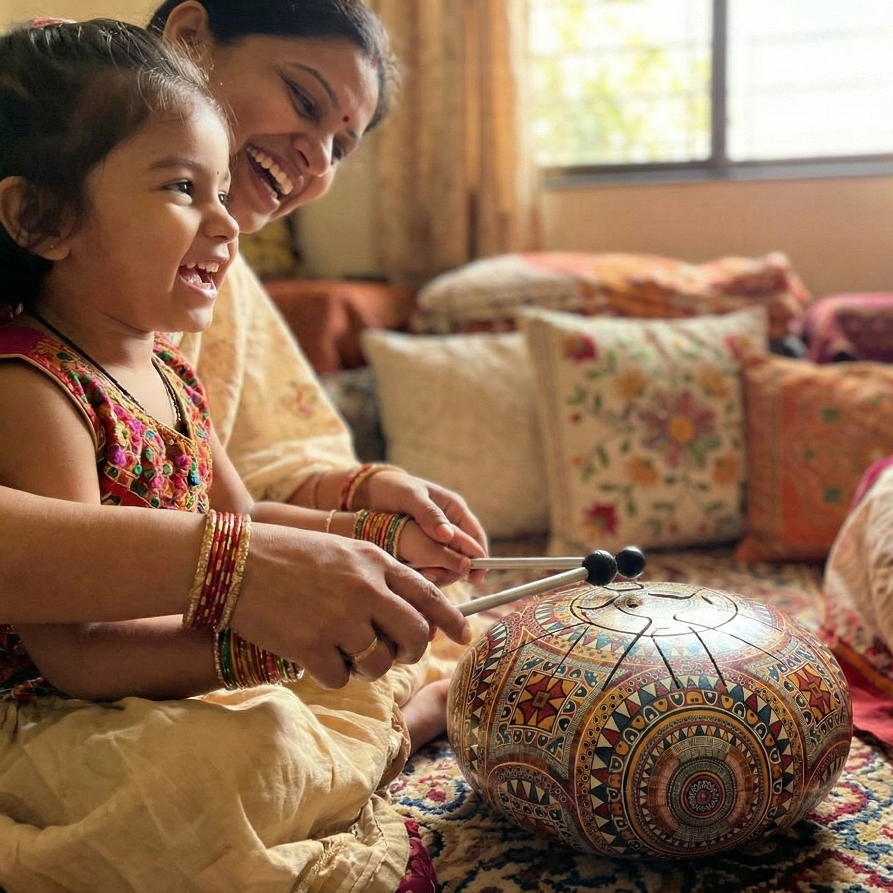 A joyful mother and child playing a colorful steel tongue drum (happy drum) together at home, showcasing it as an easy-to-learn musical instrument gift for kids and family bonding.