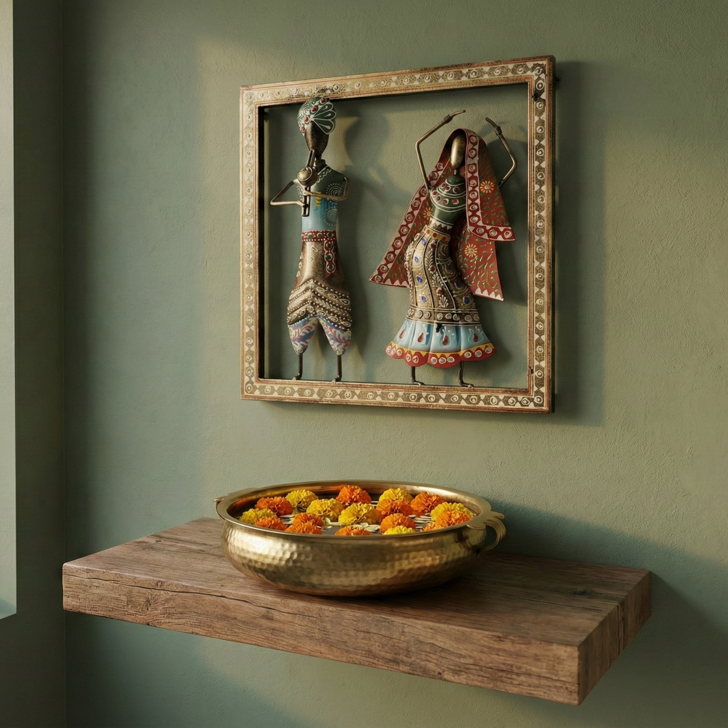 Wrought iron Kalbelia dancer and musician wall hanging displayed above a wooden shelf with flowers. Perfect ethnic wall decor for entryways or puja rooms.