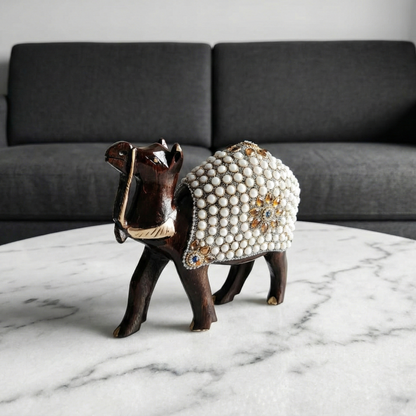 Hand-carved wooden camel figurine with pearl work placed on the centre table in the living room