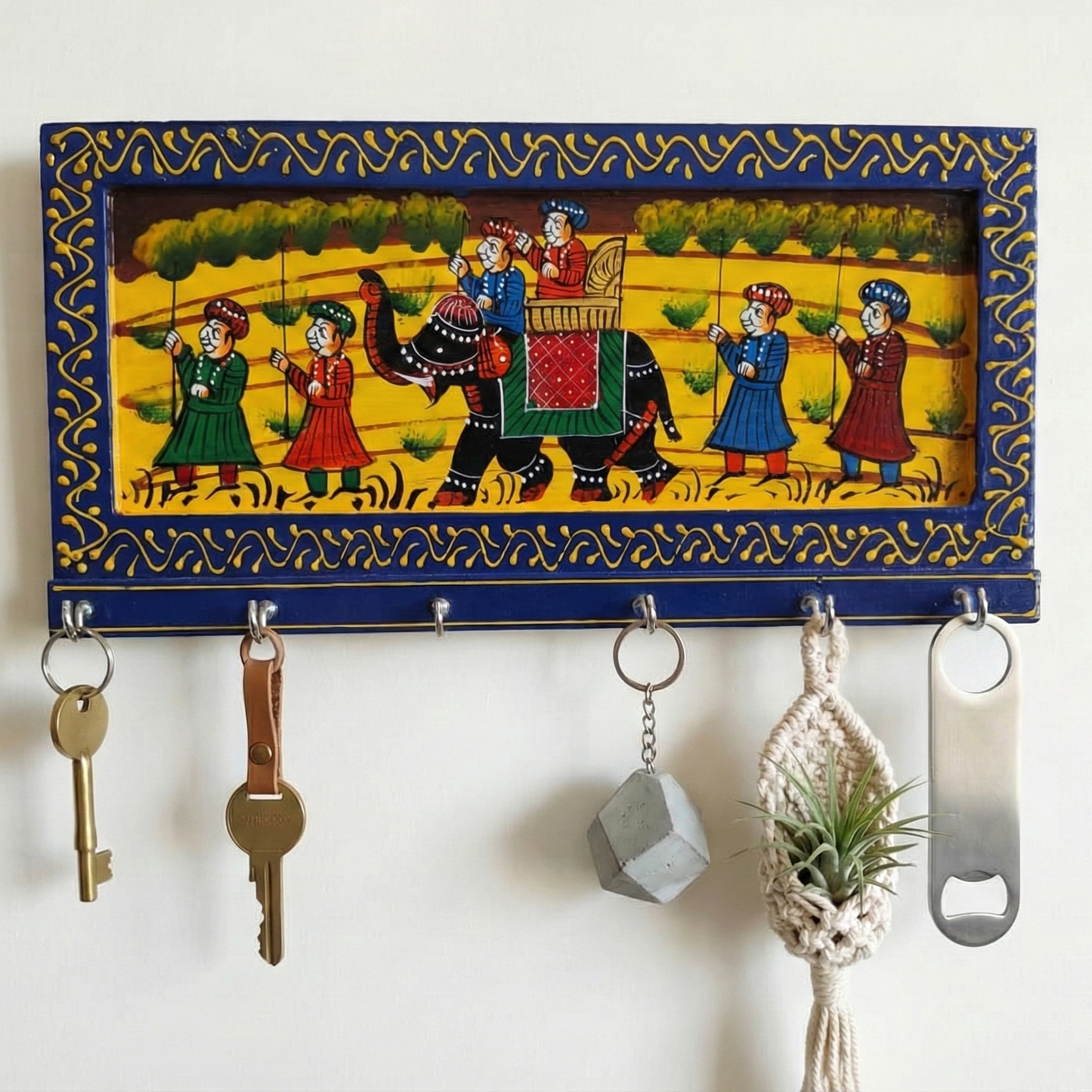 A handcrafted blue wooden key holder for the wall featuring traditional Rajasthani elephant painting