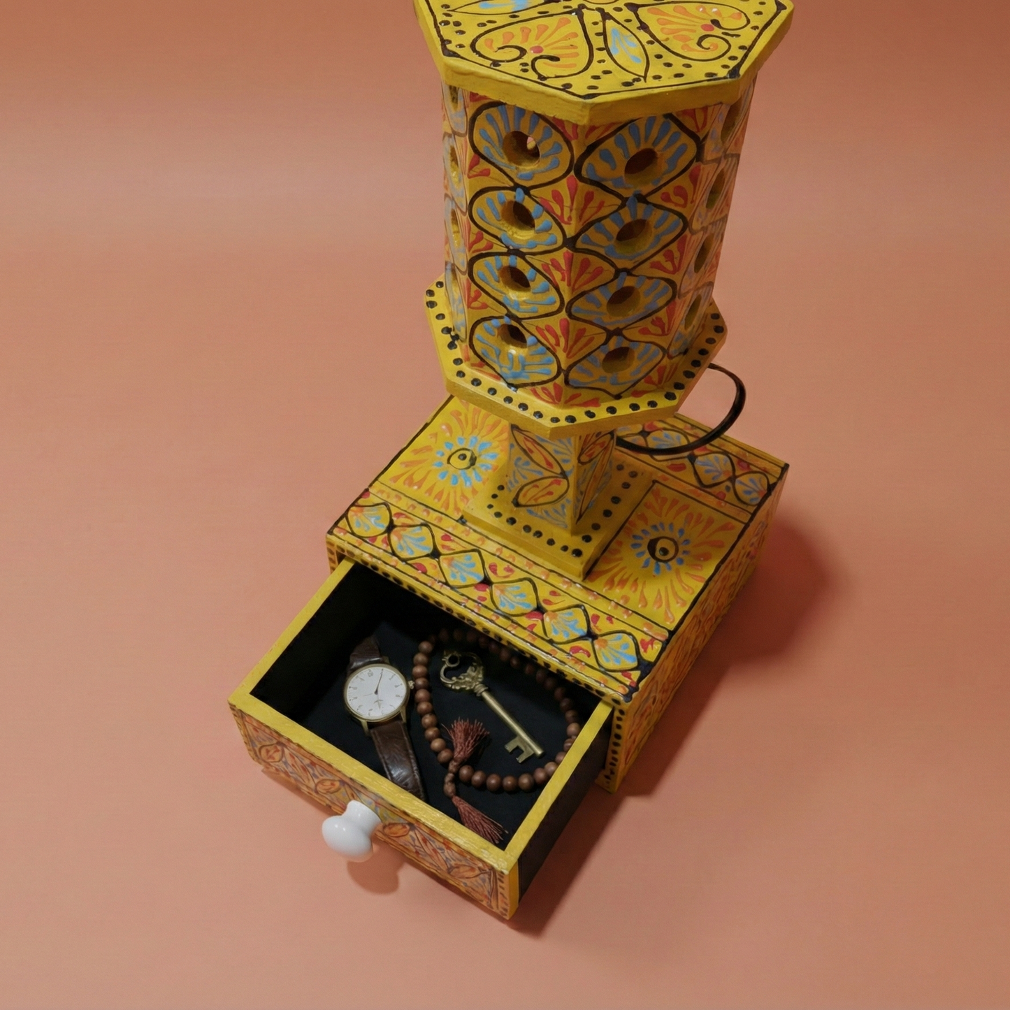 Top view of yellow wooden lamp with the storage drawer pulled open, organizing keys and accessories to show functionality.